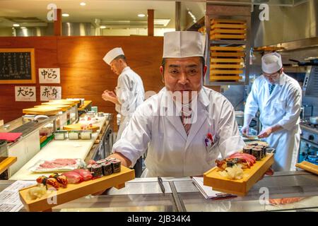 Ein Koch bietet abends in Tokio frisches Sushi an Stockfoto