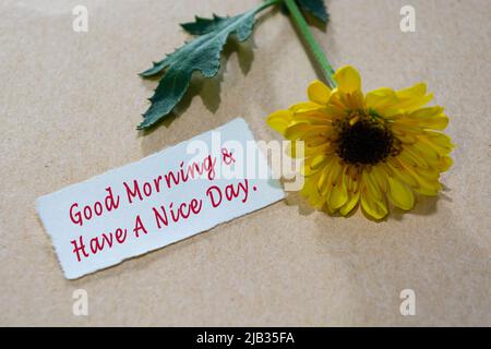 Happy Wednesday Text auf zerrissenem weißem Papier mit Sonnenblume auf Holztischhintergrund - Guten Morgen und Schönen Tag. Stockfoto