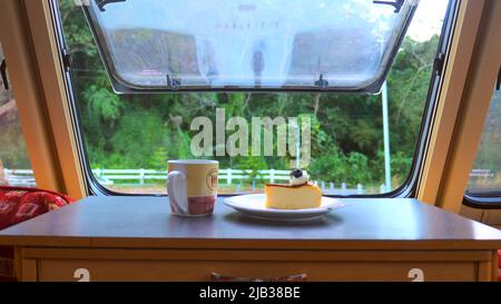 Landschaftlich schöner Blick auf das Fichte-Waldland im Sommer vom Wohnmobil-Van-Dinette-Fenster Stockfoto