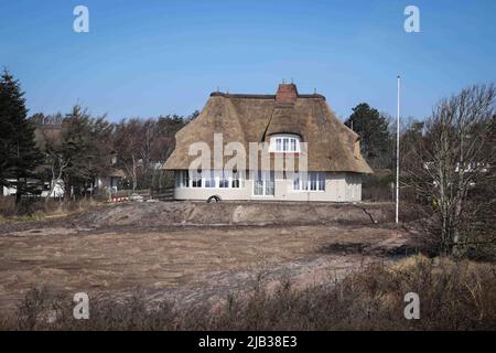 Wyk, Deutschland. 04. März 2022. Ein neues Reethaus steht in einer Siedlung nahe dem Golf Club Föhr und dem Flugplatz Wyk am Greveling Strand zwischen Nieblum und Wyk auf der Nordseeinsel Föhr. Quelle: Christian Charisius/dpa/Alamy Live News Stockfoto