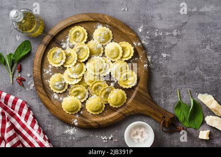 Frische rohe italienische Ravioli auf dem Tisch mit Kochzutaten. Hausmannskost Stockfoto