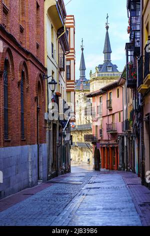 Schmale Gasse mit alten Gebäuden und Leon Rathaus im Hintergrund, Spanien. Stockfoto