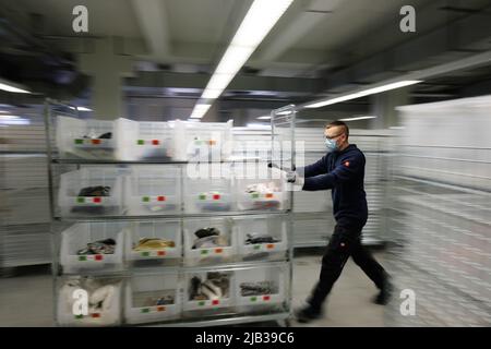 Leipzig, Deutschland. 24.. Februar 2022. Der Transport von Kleidungsstücken erfolgt bei der Online-Versandfirma Momox. Quelle: Sebastian Willnow/dpa-Zentralbild/dpa/Alamy Live News Stockfoto