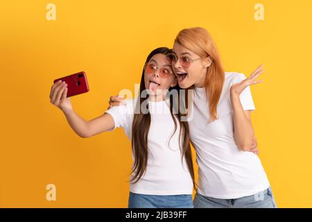 Überrascht Mutter Frau und Kind Mädchen machen Selfie auf dem Smartphone, Mutterschaft Stockfoto