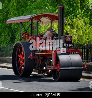 Rot-schwarzes, stationäres, schweres Dampffahrzeug, das am Straßenrand geparkt ist (L-Schild und Kennzeichen vorne) - Burley-in-Wharfedale, West Yorkshire England, Großbritannien. Stockfoto