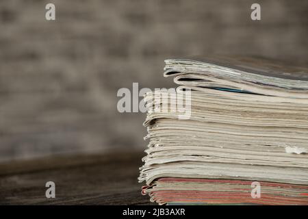 Auf dem Tisch liegt ein Stapel von Zeitschriften und Zeitungen, eine Tageszeitung Stockfoto