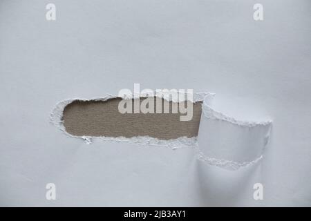 Weißes zerrissenes Papier mit Loch in der Mitte, zerrissenes Papier, Platz für Text, weißer Papierhintergrund Stockfoto
