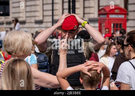 Mitglieder der Royal Military Police (RMP) unterstützen die Öffentlichkeit beim Zugang zur Mall, um sich am 1.. Juni 2022 in London, England, das Trooping der Farbe anzusehen, das mit dem Platin-Jubiläum der Königin zusammenfiel. Königin Elizabeth II. Steht seit 70 Jahren auf dem britischen Thron, die dienstälteste Monarchin der englischen Geschichte und Menschenmengen strömten nach Zentral-London, um dieses jährliche Ereignis während des Jubiläumswochenendes zu sehen. Zehntausende konnten jedoch keine der zeremoniellen Veranstaltungen sehen, da die Mall von der Polizei für mehr Besucher geschlossen wurde und stattdessen in den umliegenden Straßen und in Trafalgar blieb Stockfoto