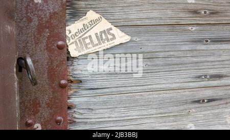 Schloss, Schlüssel, Schlüsselloch und ein Stück alte Zeitung an der alten Holztür. Das alte Stück der Zeitung enthält die Inschrift in litauischer Sprache - "so Stockfoto