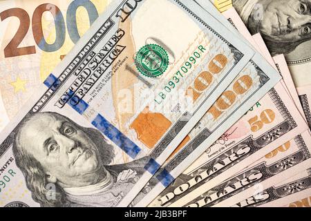 Hundert Dollarscheine auf 200 Euro-Banknoten. Euro- und Dollar-Tauschkonzept, Handel zwischen den USA und der Europäischen Union. Stockfoto