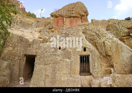 Mittelalterlicher Khachkars (armenischer Kreuzstein) Inset in the Mountain Rock, Geghard Medieval Monastery Complex, Kotayk Province of Armenia Stockfoto