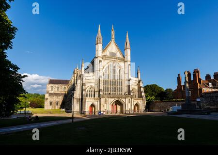 Westfront der Winchester Cathedral bei Nachmittagslicht mit blauem Himmel, Winchester, Hampshire, Südengland Stockfoto