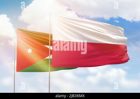 Sonniger blauer Himmel und Flaggen von polen und jordanien Stockfoto