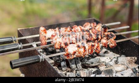 Marinierte Schaschlik, die auf einem Grillgrill über Holzkohle zubereitet wird. Shashlik oder Shish Kebab in Osteuropa beliebt Stockfoto