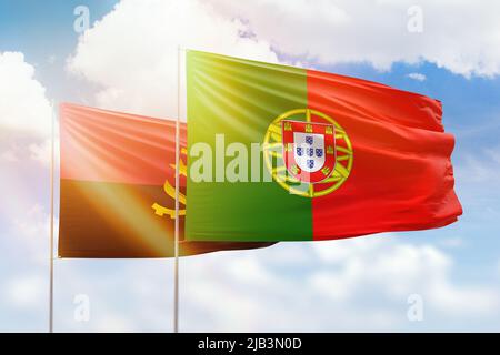 Sonniger blauer Himmel und Flaggen von portugal und angola Stockfoto