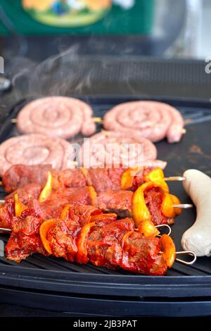 Gemischtes gegrilltes Fleisch mit Gemüse. Zubereitung von Speisen auf dem Grill Stockfoto