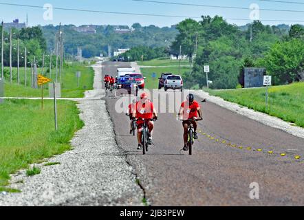 EMPORIA, KANSAS – 2. JUNI 2022 örtliche Polizeibeamte und Sheriffs-Abgeordnete, die mit Fahrrädern fahren, begleiten die Flamme der Hoffnung für die Special Olympics südlich entlang der Staatsroute 99 außerhalb von Emporia auf dem Weg 90 Meilen südlich nach Wichita während des Kansas Law Enforcement Fackellaufs, um das Bewusstsein und die Mittel zum Nutzen der Organisation zu schärfen Stockfoto