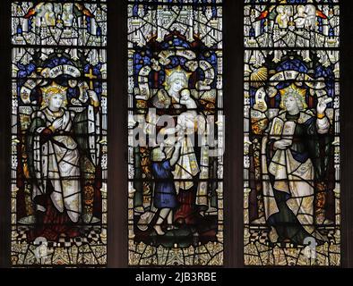 Ein Buntglasfenster der Kempe Studios, das die drei Tugenden Faith, Hope & Charity, St James the Great, Dursley, Gloucestershire, darstellt Stockfoto