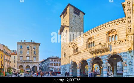 COMO, ITALIEN - 20. MÄRZ 2022: Panorama der Piazza del Duomo mit Fassade des Palastes Broletto, seinem Uhrturm, historischen Stadthäusern und Restaurants Stockfoto