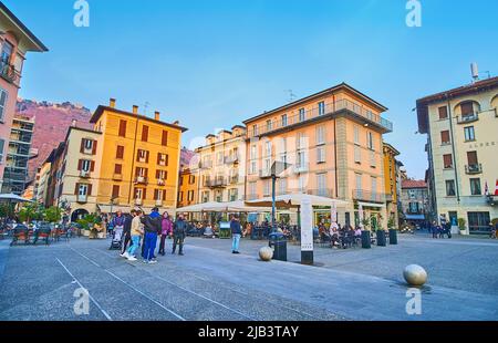 COMO, ITALIEN - 20. MÄRZ 2022: Alessandro Volta Platz in der Altstadt mit historischen Häusern, Cafés und Bergen im Hintergrund, am 20. März in Como Stockfoto