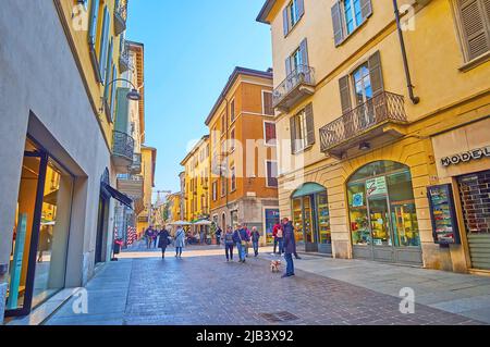 COMO, ITALIEN - 20. MÄRZ 2022: Historische Fußgängerzone Vittorio Emanuele II Straße, in der Altstadt gelegen und mit Geschäften und Restaurants gesäumt, am 20. März Stockfoto