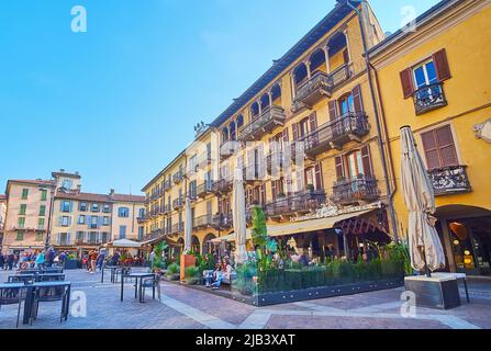 COMO, ITALIEN - 20. MÄRZ 2022: Die Restaurants Terrassen vor den historischen Häusern des Domplatzes, am 20. März in Como Stockfoto