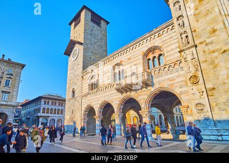 COMO, ITALIEN - 20. MÄRZ 2022: Die Fassade des Palastes Broletto (Sitz der Gemeinde) mit schlankem Uhrturm, Arkade, Säulen und Skulpturen der Kathedrale Stockfoto