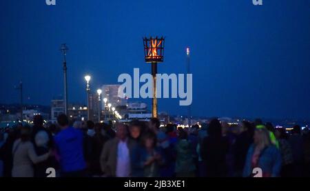 Hove , Brighton UK 2. June 2022 - die Beleuchtung des Platinum Jubilee LED Leuchtfeuers der Königin an der Küste von Hove heute Abend als Leuchtfeuer im ganzen Land während der Feierlichkeiten beleuchtet werden : Credit Simon Dack / Alamy Live News Stockfoto