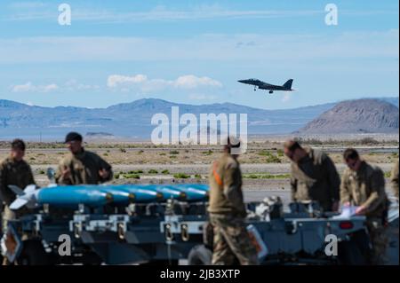 US Air Force-Piloten vom 366. Fighter Wing, Mountain Home Air Force Base, Idaho, beobachten, wie ein F-15E Strike Eagle am Wendover Airfield, Wendover, Ut., 21. Mai 2022 vorbeifliegt. Der 366. Fighter Wing unterhält zwei Jagdgeschwader, die den F-15E Strike Eagle fliegen: Das 389. Fighter Squadron und das 391. Fighter Generation Squadron. (USA Luftwaffe Foto von Senior Airman Cole Yardley) Stockfoto