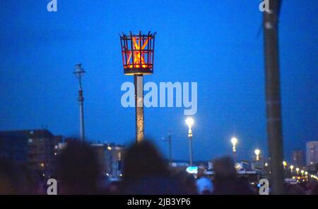 Hove , Brighton UK 2. June 2022 - die Beleuchtung des Platinum Jubilee LED Leuchtfeuers der Königin an der Küste von Hove heute Abend als Leuchtfeuer im ganzen Land während der Feierlichkeiten beleuchtet werden : Credit Simon Dack / Alamy Live News Stockfoto