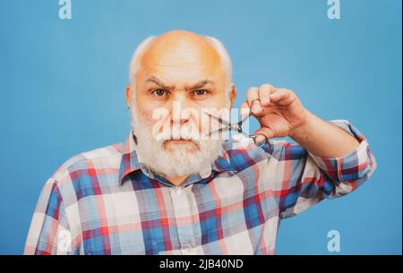 Friseurschere. Mann mittleren Alters. Porträt eines alten kahlen Mannes bärtiger Mann mit grauem Schnurrbart. Stockfoto