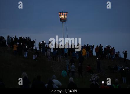 Mountsorrel, Leicestershire, Großbritannien. 2.. Juni 2022. Die Menschen beobachten, wie der Leuchtfeuer auf dem Castle Hill während der Feierlichkeiten zum Platin-Jubiläum leuchtet. Tausende von Leuchttürmen wurden in den Regionen Großbritanniens angezündet, um Königin Elizabeth IIÕs 70.-jähriges Thronjahr zu markieren. Credit Darren Staples/Alamy Live News. Stockfoto