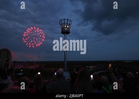 Mountsorrel, Leicestershire, Großbritannien. 2.. Juni 2022. Während der Feierlichkeiten zum Platinum Jubilee explodiert hinter dem Leuchtfeuer auf dem Castle Hill ein Feuerwerk. Tausende von Leuchttürmen wurden in den Regionen Großbritanniens angezündet, um Königin Elizabeth IIÕs 70.-jähriges Thronjahr zu markieren. Credit Darren Staples/Alamy Live News. Stockfoto