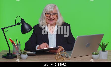 Erfolgreiche Einstellung genehmigt. Senior ceo Geschäftsfrau Direktor sitzen am Arbeitsplatz, Blick auf die Kamera, Interview Job Diskussion Videokonferenz online. Arbeiten im grünen Büro Stockfoto