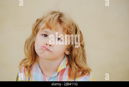 Kindliche Emotionen. Unglückliches, verwirrendes Kind. Kindheit. Isoliert. Lustiger Junge. Stockfoto