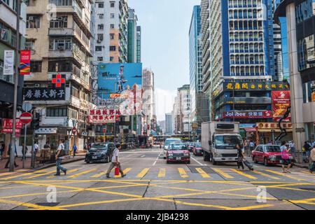 Die Argyle Street in Hongkong ist eine lebhafte Innenstadt-Szene mit Verkehr, Fußgängern und hoch aufragenden Gebäuden Stockfoto