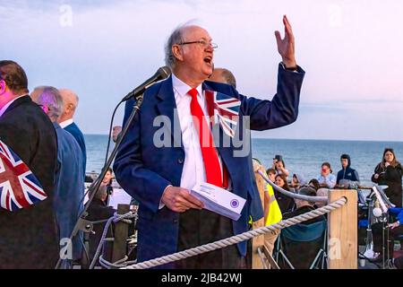 Hove Promenade, Hove Lagoon, City of Brighton & Hove, East Sussex, Großbritannien. Hove Beacon Neuentage feiert die Feierlichkeiten zum Platin-Jubiläum von Königin Elizabeth II. Das Leuchtfeuer wurde mit einem speziell entworfenen LED-Display angezündet, das vom lokalen Künstler Eleni Shiarlis erstellt wurde. Dies wird eine permanente Anzeige sein, die jeden Abend eingeschaltet wird. Vor der feierlichen Beleuchtung wurden Hunderte von Anwohnern von Der A-cappella-Gruppe Sussex Kings of Harmony unterhalten. 2.. Juni 2022. David Smith/Alamy News Stockfoto