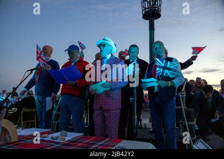 Hove Promenade, Hove Lagoon, City of Brighton & Hove, East Sussex, Großbritannien. Hove Beacon Neuentage feiert die Feierlichkeiten zum Platin-Jubiläum von Königin Elizabeth II. Das Leuchtfeuer wurde mit einem speziell entworfenen LED-Display angezündet, das vom lokalen Künstler Eleni Shiarlis erstellt wurde. Dies wird eine permanente Anzeige sein, die jeden Abend eingeschaltet wird. Vor der feierlichen Beleuchtung wurden Hunderte von Anwohnern von Der A-cappella-Gruppe Sussex Kings of Harmony unterhalten. 2.. Juni 2022. David Smith/Alamy News Stockfoto