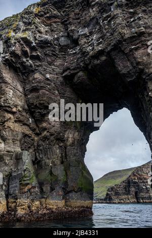 Arch of Stori Drangur of Drangarnir Felsformation auf der Insel Vagar von einem Boot aus gesehen, Färöer-Inseln Stockfoto