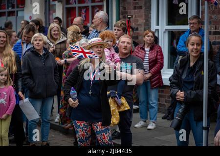 Lymm, KH, Großbritannien. 2.. Juni 2022. Donnerstagabend, 2. Juni 2022 - Menschenmassen versammelten sich um den Lower Dam in Lymm, Ceshire, England, um das Platin-Jubiläum der Königin zu feiern, wo einer von vielen Leuchttürmen im ganzen Land beleuchtet wurde.Quelle: John Hopkins/Alamy Live News Stockfoto