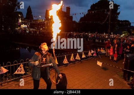 Lymm, KH, Großbritannien. 2.. Juni 2022. Donnerstagabend, 2. Juni 2022 - Menschenmassen versammelten sich um den Lower Dam in Lymm, Ceshire, England, um das Platin-Jubiläum der Königin zu feiern, wo einer von vielen Leuchttürmen im ganzen Land beleuchtet wurde.Quelle: John Hopkins/Alamy Live News Stockfoto