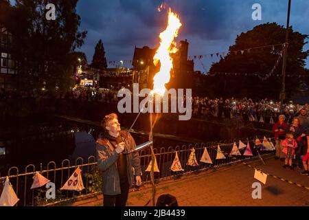 Lymm, KH, Großbritannien. 2.. Juni 2022. Donnerstagabend, 2. Juni 2022 - Menschenmassen versammelten sich um den Lower Dam in Lymm, Ceshire, England, um das Platin-Jubiläum der Königin zu feiern, wo einer von vielen Leuchttürmen im ganzen Land beleuchtet wurde.Quelle: John Hopkins/Alamy Live News Stockfoto