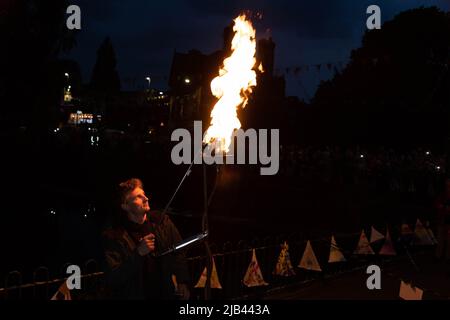 Lymm, KH, Großbritannien. 2.. Juni 2022. Donnerstagabend, 2. Juni 2022 - Menschenmassen versammelten sich um den Lower Dam in Lymm, Ceshire, England, um das Platin-Jubiläum der Königin zu feiern, wo einer von vielen Leuchttürmen im ganzen Land beleuchtet wurde.Quelle: John Hopkins/Alamy Live News Stockfoto