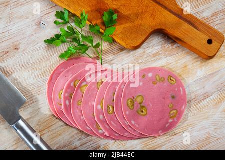 Bild von Mortadela-Wurst mit in Scheiben geschnittenen Oliven Stockfoto