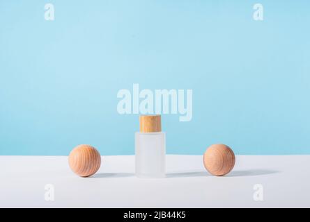 Kosmetische Glasflasche auf blauem Hintergrund. Produktpräsentation: Blauer flüssiger Hautpflegetoner. .Medizinische Hautpflege und kosmetische Creme Mockup mit stilvollen Stockfoto