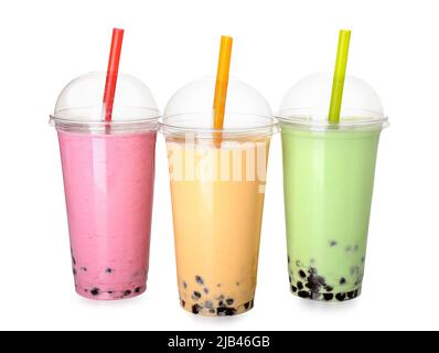 Plastikbecher mit verschiedenen leckeren Bubble Tea auf weißem Hintergrund Stockfoto