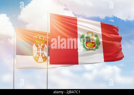 Sonniger blauer Himmel und Flaggen von peru und serbien Stockfoto