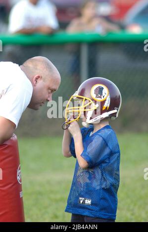 Coach im Gespräch mit Kind bei vollem Kontakt Fußball Praxis über Spiel und Lernregeln Mann Junge Kind Stockfoto