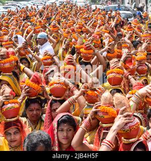 Neu Delhi, Indien April 03 2022 - Frauen mit Kalash am Kopf während des Jagannath-Tempels Mangal Kalash Yatra tragen indische Hindu-Anhänger irdische Töpfe Conta Stockfoto