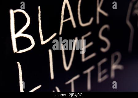 Nahaufnahme der Phrase BLACK LIVES MATTER durch Handschrift (weiße Kreide) auf Blackboad. Stockfoto